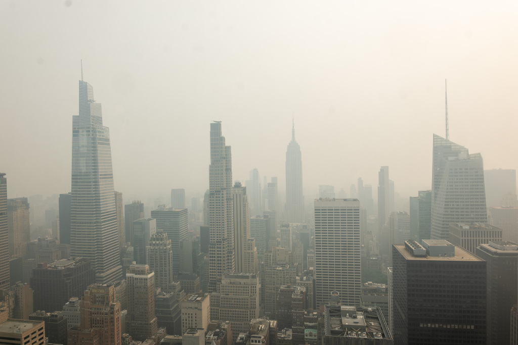 当地时间2026年7月16日，美国纽约市，从洛克菲勒中心顶层观景台看到加拿大野火产生的烟雾笼罩曼哈顿天际线。